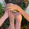 Close-up of four friends' hands, each wearing a matching personalized Classic 4 Birthstone bracelet in 14k yellow gold.