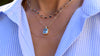 Woman wearing a Warren Nantucket Blue Topaz pendant on an Adelaide Mini chain & a Mia necklace featuring a 1.24mm rolo chain.