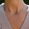 Woman wearing a Pink Awareness Bayberry necklace featuring eleven 4 mm pink tourmalines & moonstones bezel set in 14k gold