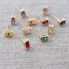 Scattered assortment of various Providence stud earrings, all featuring a single 2x4mm baguette cut, prong set gemstone.