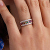 Woman's hand adorned with Rosecliff Stackable Rings featuring 2mm rubies, citrines, emeralds, sapphires, amethysts, pink sapphires