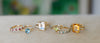 Six rings lay side-by-side consisting of Rosecliff Stackable rings, a Grand ring, a Greenwich ring, and Warren rings.