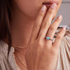 Woman's hand adorned with a 14k gold Rosecliff Grand Ring, featuring a 6 mm round, briolette-cut Turquoise and eight alternating 2 mm round-cut Diamonds and Nantucket Blue Topazes.