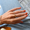 Woman's hand wearing Haverhill 14k gold rings, including a 14k gold Rosecliff Grand Ring with a 6 mm briolette-cut Citrine and eight smaller 2 mm round-cut Citrines.