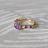 Woman's hand wearing a 14k gold Rosecliff Grand Ring with a 6 mm briolette-cut Amethyst and eight 2 mm round-cut alternating Diamonds and Amethysts.