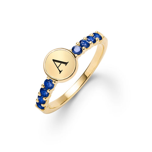 14k gold Rosecliff Letter Ring, featuring a flat engraved letter disc nestled between alternating 2 mm faceted round cut, prong set Sapphire - aspect view