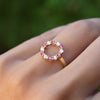 Hand with a Rosecliff small open circle ring featuring twelve alternating pink sapphires & diamonds prong set in 14k gold