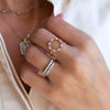 Woman wearing jewelry including a gold Rosecliff open circle ring featuring alternating 2 mm pink sapphires and diamonds