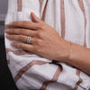 Woman's hand wearing three Rosecliff Rings, including Diamond & Sapphire Stackable Rings in 14k gold.