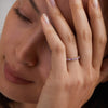 Woman showcasing a Rosecliff stackable ring featuring eleven alternating 2mm pink sapphires and diamonds prong set in 14k gold