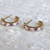 Pair of De-Lovely Rosecliff gold huggie earrings each featuring 9 alternating pink tourmalines, white topaz & amethysts