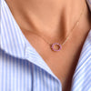 Woman with a Rosecliff small open circle necklace featuring twelve 2mm round cut pink sapphires prong set in 14k gold