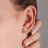 Woman wearring a Diamond Star of David Stud Earrings in Solid 14k yellow Gold, featuring thirty-seven 1mm faceted round cut Diamonds.