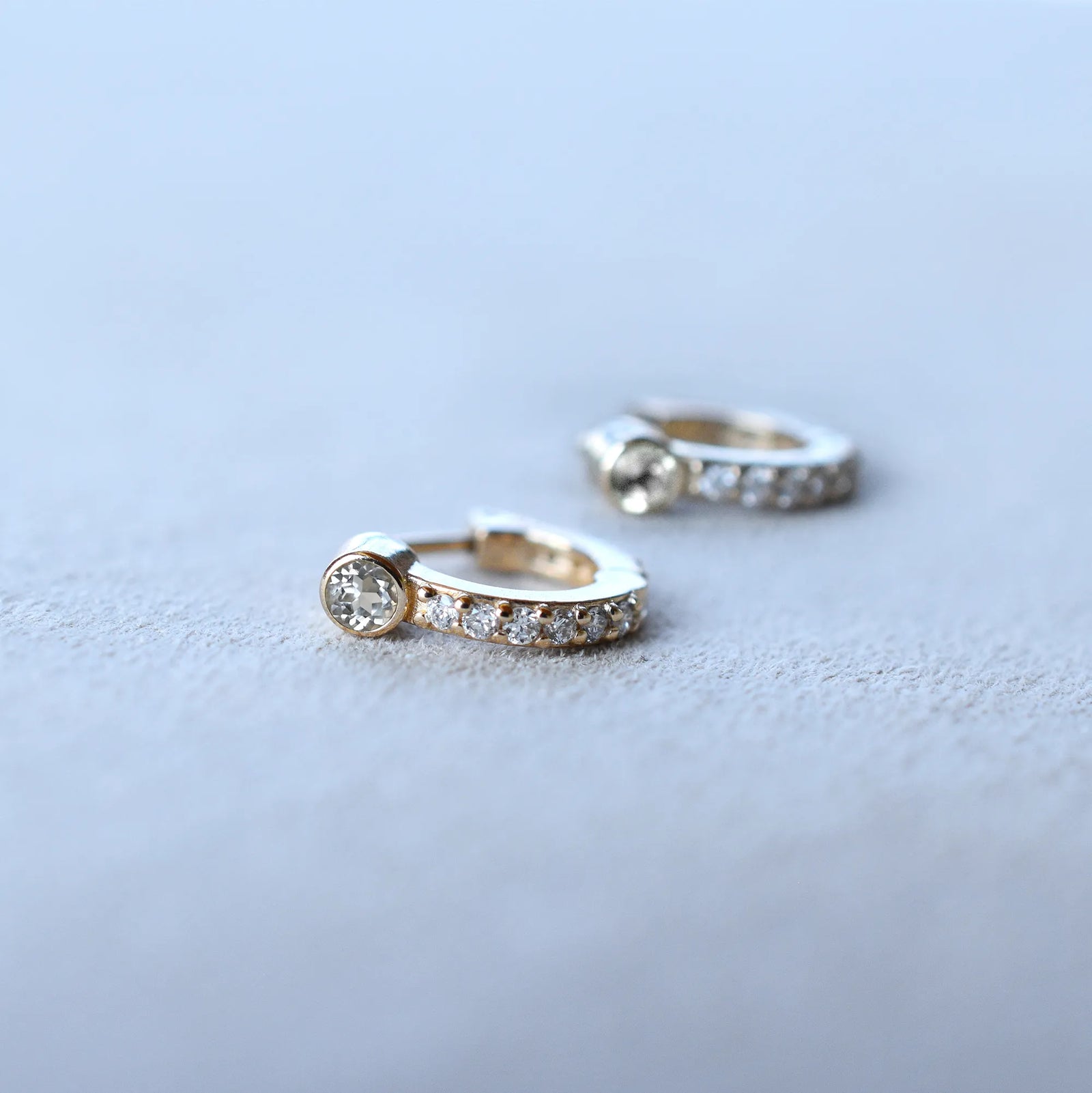 Tiny White Topaz Huggie Hoops with Diamonds in 14k Gold (April)