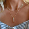 Woman wearing a Providence 6 White Topaz Pendant, personalized Classic 6 Birthstone necklace, and Adelaide Mini necklace.