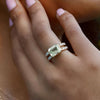 Woman's hand wearing a 14k yellow gold Warren Horizontal Green Amethyst Ring with Diamonds, showcasing an 8 x 10mm Green Amethyst and 16 prong-set diamonds.