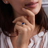 Woman showcasing a 14k yellow gold Warren Horizontal Sapphire Ring with Diamonds, showcasing an 8 x 10mm Sapphire and 16 prong-set diamonds.