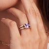 Woman's hand wearing the 14k gold Warren Horizontal Amethyst Ring, a statement piece with a hand-faceted 8x10mm amethyst and split-shank band.