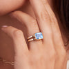 Woman's hand showcasing a 14k yellow gold Warren Horizontal Aquamarine Ring, featuring an Aquamarine-cut 8 x 10mm Nantucket Blue Topaz, hand-set horizontally in a 14k-gold bezel.