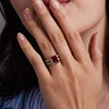 Woman wearing a 14k yellow gold Warren Vertical Garnet Ring with accent diamonds featuring one 10 x 8 mm emerald cut bezel set garnet.