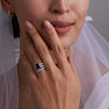 Bride showcasing a 14k yellow gold Rosecliff ring and Warren Vertical Ring with accent diamonds featuring one 10 x 8 mm emerald cut bezel set Sapphire.