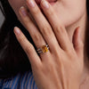 Woman wearing a 14k yellow gold Warren Vertical Citrine Ring with accent diamonds featuring one 10 x 8 mm emerald cut bezel set citrine.