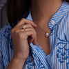 Woman showcasing a 14k yellow gold Warren Vertical Rose Quartz Ring, featuring one 10 x 8 mm Rose Quartz cut, bezel set.