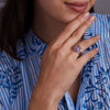 Woman wearing a 14k yellow gold Warren Vertical Amethyst Ring, showcasing one 10 x 8 mm emerald cut, bezel set Amethyst in 14k Gold.