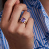 Woman adorned with a 14k yellow gold Warren Vertical Amethyst Ring, showcasing one 10 x 8 mm emerald cut, bezel set Amethyst in 14k Gold.