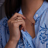 Woman adorned with a 14k yellow gold Warren Vertical Garnet Ring, showcasing one 10 x 8 mm Garnet cut, bezel set Garnet.