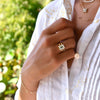 Woman adorned with assorted Haverhill 14k gold rings, including a Warren Vertical Ring, showcasing one 10 x 8 mm Green Amethyst cut, bezel set Green Amethyst.