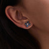 Woman adorned with a Greenwich 4 Birthstone Earrings in 14k Gold featuring 4 mm faceted round cut, prong set Alexandrites and one 2.1 mm Diamond. 