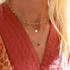 A woman wearing a Newport Moonstone necklace, a Venus necklace, and a Greenwich Solitaire Alexandrite & Diamond necklace.
