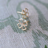 Close-up of a pair of 14k yellow gold stud earrings featuring 9.1mm cutout clovers.