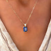 Woman wearing a Warren Sapphire Pendant featuring a 10x8mm center stone and diamond encrusted bale on an Adelaide Mini chain.
