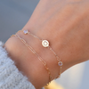 Personalized Heart Disc & Classic 2 Birthstone bracelet on a 1.17mm cable chain & Adelaide Mini bracelet in 14k yellow gold.