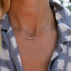 Woman wearing a personalized Rosecliff Bar necklace featuring eleven 2mm prong set gemstones on a 1.17mm cable chain.