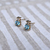 Pair of Greenwich Solitaire earrings, each featuring a 4mm faceted round cut Nantucket blue topaz and one 2.1mm diamond.