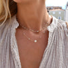 Woman wearing a Newport Moonstone necklace and personalized Classic 1 Letter & 4 Moonstone necklace in 14k yellow gold.