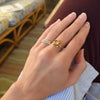 Hand wearing a Greenwich ring featuring five 4 mm faceted round cut citrines and one 2.1 mm diamond prong set in 14k gold