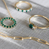 Jewelry including a Greenwich ring featuring one 4 mm emerald and one 2.1 mm diamond prong set in 14k gold - a close-up