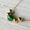 Bristol Bead necklace featuring an 8mm green agate bead centered between four 6mm gold beads on a 14k yellow gold chain.