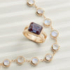 Assorted jewelry featuring a 14k gold Warren ring with an emerald-cut Alexandrite, paired with a moonstone necklace.