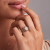 Woman's hand adorned with a stunning 14k gold Palmer ring featuring 98 small and 7 larger prong-set round-cut diamonds.