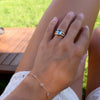 Woman's hand wearing a Warren ring in 14k gold with accent diamonds featuring one 10 x 8 mm aquamarine