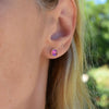 Woman wearing a pair of 14k yellow gold Grand stud earrings each featuring one 6 mm briolette cut Pink Sapphire