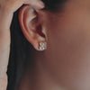 Woman showcasing Greenwich 4 Birthstone earrings in 14k yellow gold featuring four 4 mm white topaz and one 2.1 mm diamond.