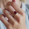 Woman adorned with a 14k yellow gold Warren Vertical Ruby Ring, showcasing one 10 x 8 mm emerald cut, bezel set Ruby.