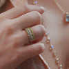 Woman wearing Rosecliff Stackable rings, including Nantucket blue topaz Stackable ring, one with alternating diamonds, prong set in 14k yellow gold