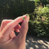 Woman showing a pair of 14k yellow gold Grand stud earrings each featuring one 6 mm briolette cut peridot